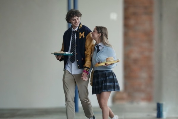 Miles Palmer e Tessa Lane caminham juntos pelo campus.